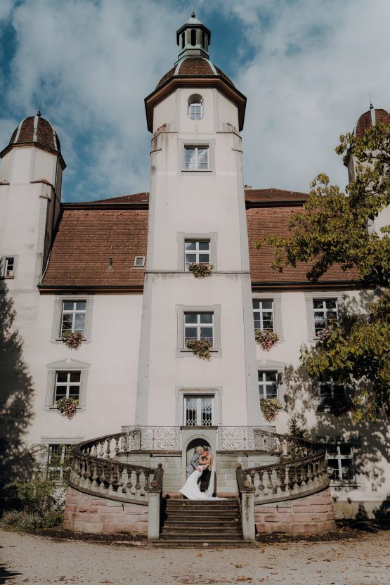 Ein Brautpaar vor einem alten Schloss