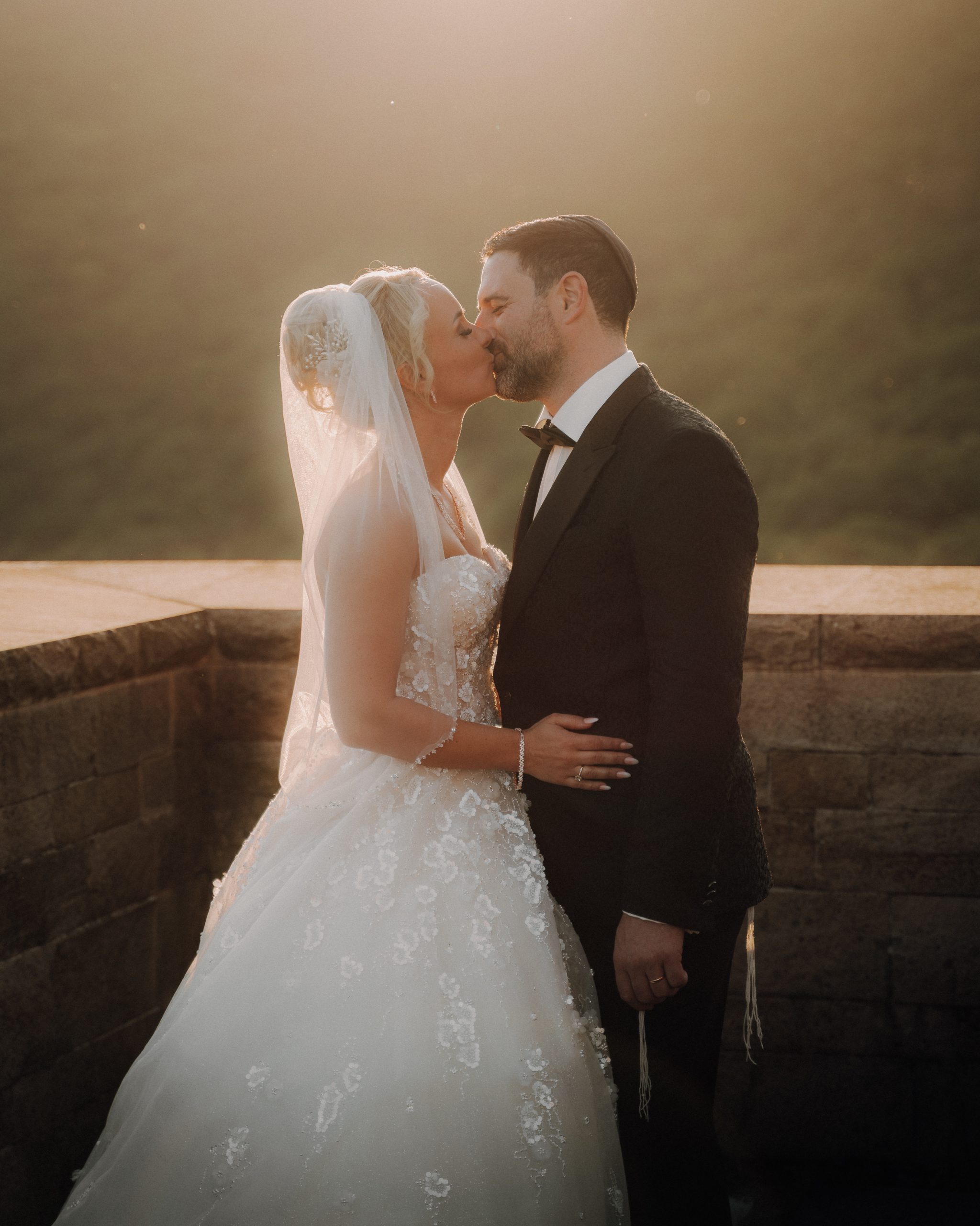 Ein Brautpaar küsst sich romantisch im Sonnenuntergang