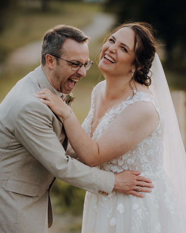 Das Brautpaar lacht gemeinsam herzlich