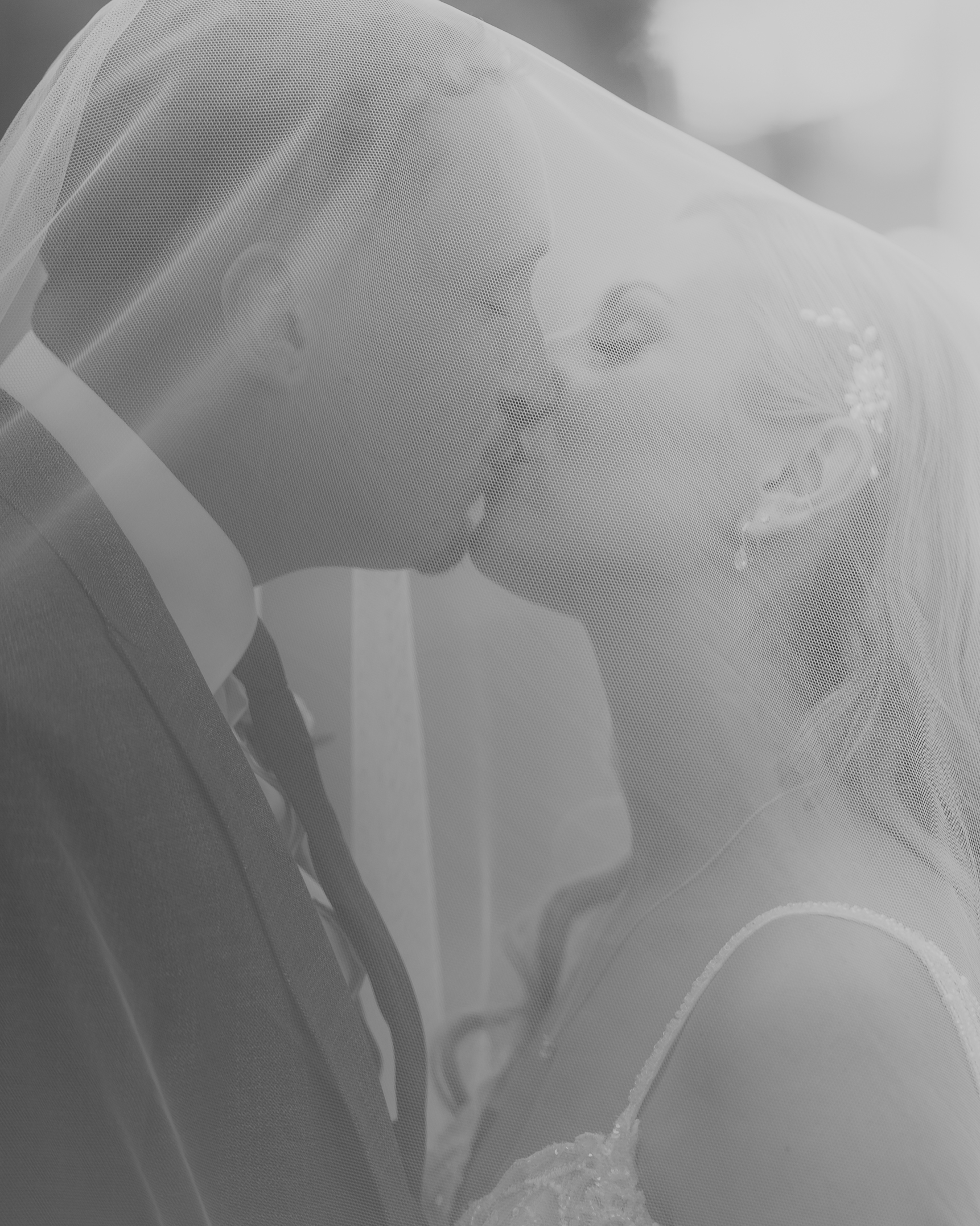 Das Brautpaar küsst sich unter dem Schleier